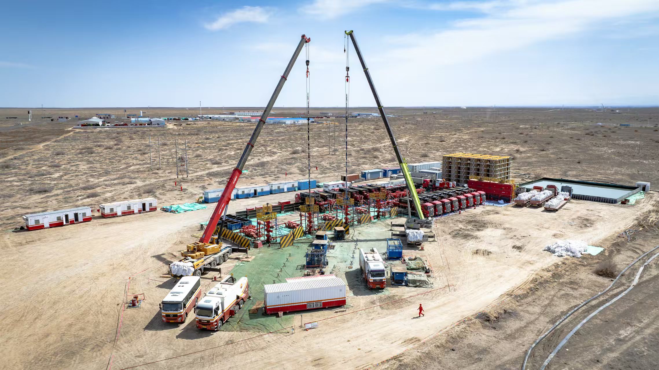 6月中旬，準噶爾盆地被陽光照得熾熱。在廣袤無垠的戈壁荒漠之上，鉆機的轟鳴聲此起彼伏，生產作業車輛往來穿梭，一片繁忙景象。今年，恰逢新疆油田勘探開發70周年。新疆油田的各個油氣生產單位緊緊抓住生產的黃金季節，一場與時間賽跑的上產熱潮正如火如荼地展開。圖為烈日下，30多臺壓裂車矗立在新疆油田瑪湖油區，將壓裂液注入3000米深的儲層。