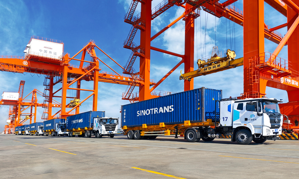 “十四五”時期，招商局集團旗下中國外運持續提升產業鏈供應鏈韌性與安全水平，自有海外服務網絡覆蓋全球45個國家和地區；穩定運營全貨機定期國際航線，年度固定運力約26萬噸；國際班列運量累計突破200萬標箱，汽運網絡覆蓋全國各省份超300個城市，自動駕駛高速干線商業運營里程超300萬公里。圖為自動駕駛電動集卡車隊行駛在中國外運江門高新港。