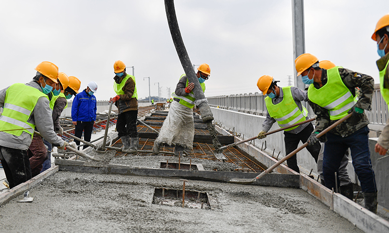 杭紹臺鐵路連接浙江杭州、紹興和臺州三個設區市，線路設計時速350公里，預計今年年底前具備開通運營條件。圖為2月17日，杭紹臺鐵路中鐵三局參建工人在位于浙江紹興上虞區境內的紹興特大橋進行軌道底板澆筑施工。（新華社記者 黃宗治 攝）