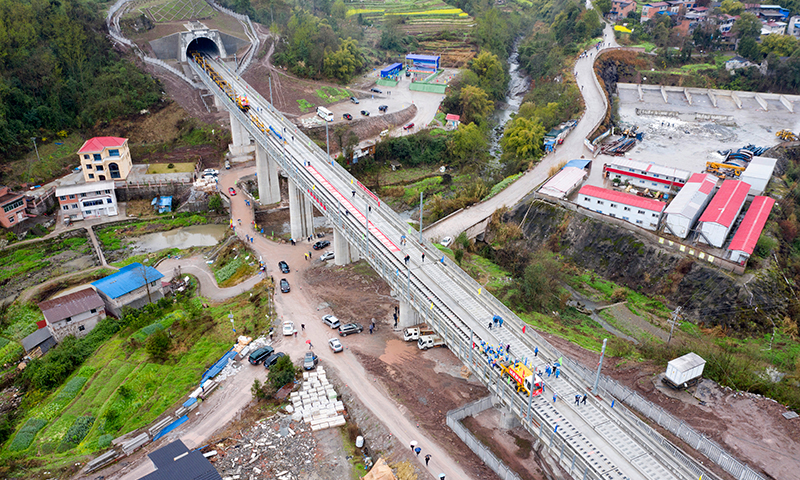 3月1日，隨著第一組500米長鋼軌鋪入無砟軌道，由中鐵十一局負責的鄭萬高鐵重慶段鋪軌工程正式啟動。圖為3月1日，在鄭萬高鐵重慶段施工現場，施工人員在進行鋪軌作業。(新華社記者 唐奕 攝)
