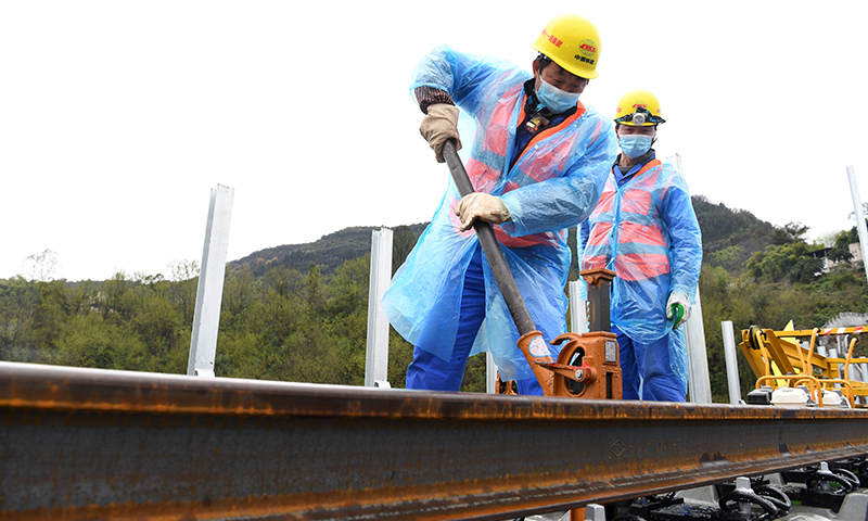圖為3月1日，在鄭萬高鐵重慶段施工現場，施工人員進行鋪軌作業。(新華社記者 唐奕 攝)