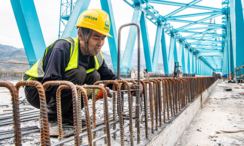 清水坪烏江特大橋位于武陵山區腹地的重慶市彭水苗族土家族自治縣境內，是渝湘高鐵重慶至黔江段“六隧五橋”之一和全線重難點工程。大橋全長804.6米，主跨240米，一跨過江，為國內首座雙Y型單拱肋主拱結構無砟軌道高速鐵路橋梁。該項目于2020年開工建設，目前已完成建設進度90%，進入最后收尾階段。圖為3月16日，工人在渝湘高鐵清水坪烏江特大橋建設現場施工作業。新華社記者 唐奕 攝
