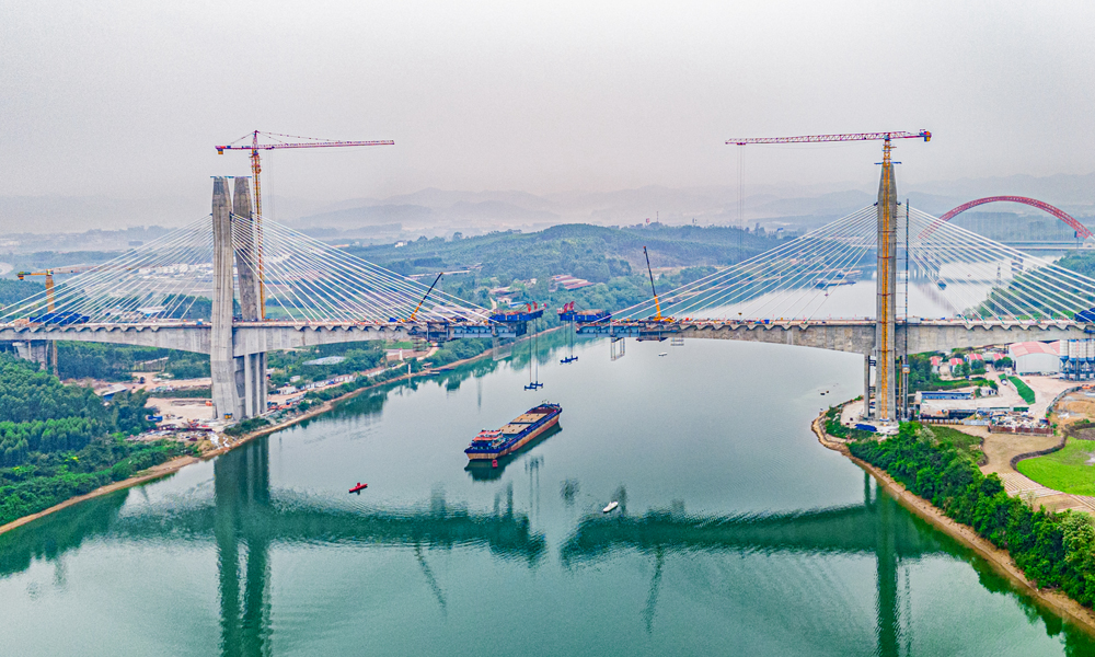 近日，南寧至深圳高速鐵路重點控制性工程——六律邕江特大橋最后一塊鋼梁完成吊裝焊接，標(biāo)志著由中國鐵建所屬中鐵十四局承建的國內(nèi)在建高鐵最大跨徑鋼混矮塔斜拉橋順利合龍。圖為合龍現(xiàn)場航拍。