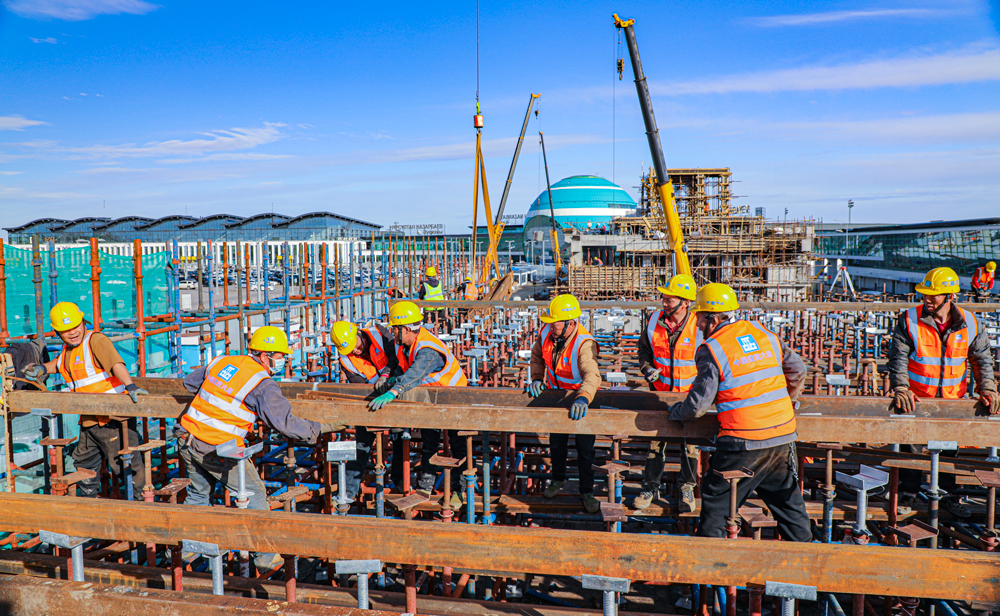 哈薩克斯坦阿斯塔納輕軌項(xiàng)目，是中亞地區(qū)第一條城市輕軌線路，也是中亞地區(qū)第一條全部采用中國(guó)標(biāo)準(zhǔn)和中國(guó)裝備建造的軌道交通項(xiàng)目。該項(xiàng)目全長(zhǎng)約22.4公里，中國(guó)建筑旗下中建六局承建了其中的18.34公里，共14個(gè)車站、15個(gè)區(qū)間及1個(gè)車輛段。目前，項(xiàng)目建設(shè)正在穩(wěn)步推進(jìn)中。圖為中方建設(shè)者在努爾蘇丹國(guó)際機(jī)場(chǎng)附近的建設(shè)區(qū)間進(jìn)行現(xiàn)澆梁支架主龍骨安裝作業(yè)。