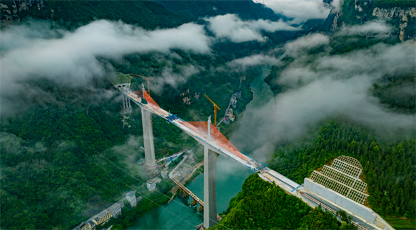 據(jù)統(tǒng)計(jì)，磨寨烏江特大橋共澆筑混凝土約15萬(wàn)立方米，安裝鋼筋約2.2萬(wàn)噸，需要分成37個(gè)5到6米的小節(jié)段，一節(jié)一節(jié)多個(gè)循環(huán)施工。項(xiàng)目建設(shè)團(tuán)隊(duì)量身定制了一套超高墩、大截面、重型全封閉智能液壓爬模系統(tǒng)，將各個(gè)作業(yè)面的位移值、位移差值、液壓系統(tǒng)壓力值以及風(fēng)速值清晰集成于控制柜的顯示屏上，施工人員可以遠(yuǎn)程監(jiān)控模架運(yùn)行數(shù)據(jù)及實(shí)時(shí)運(yùn)行情況，通過(guò)指尖完成全套操作。在智能化、數(shù)字化的系統(tǒng)幫助下，大橋一天可以“長(zhǎng)高”1米多，比傳統(tǒng)手動(dòng)機(jī)械系統(tǒng)效率高25%。