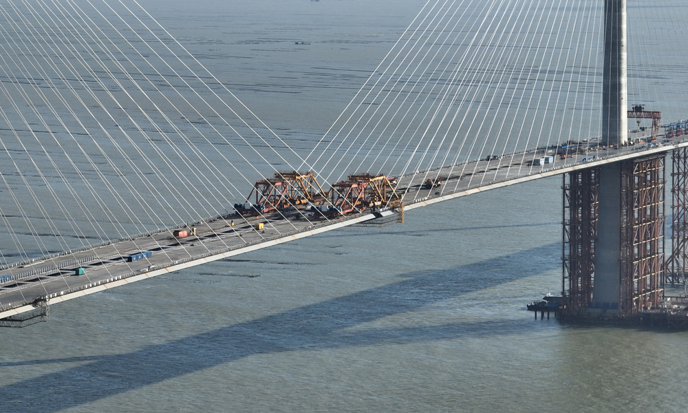 黃茅海大橋跨越黃茅海海域的兩條航道，采用3塔2跨設(shè)計(jì)，是一座獨(dú)柱式雙索面全漂浮體系斜拉橋。大橋單孔跨徑720米，橋梁全長(zhǎng)2200米，共計(jì)16種梁段類型，最重鋼箱梁達(dá)420噸。大橋橋面采用分體式鋼箱梁設(shè)計(jì)，由兩個(gè)鋼箱梁及橫向連接箱組成，橋面總寬50.4米，是分體式鋼箱梁在廣東省內(nèi)首次大規(guī)模應(yīng)用。