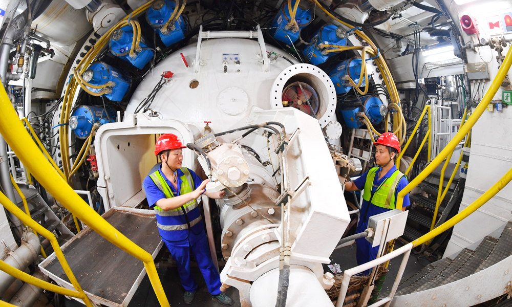 據介紹，隧道最大埋深53米，連續穿越密集建構筑物和珠江多個水道，地質條件復雜，周邊交通繁忙，施工難度大、管理要求高。項目團隊在盾構機進行了針對性設計，配備伸縮式主驅動、伸縮攝像頭、自動測量監控系統、刀具磨損檢測等多項創新技術。施工中采取“原位保護”、樁基托換等，實現了歷史保護建筑毫米級沉降控制，最快月掘進324米，創造我國華南地區復合地層超大直徑泥水盾構掘進紀錄。圖為技術人員檢查盾構機工作狀態。