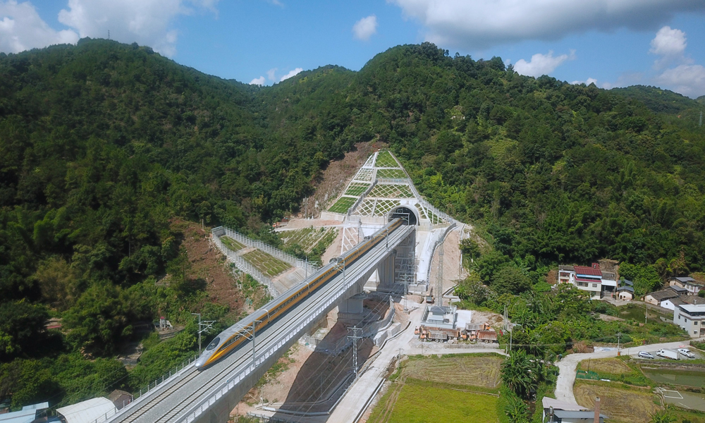 近日，由中國鐵建旗下中鐵十二局、中鐵二十五局等單位參建的龍龍高鐵梅龍段（梅州西至龍川西段）進入試運行階段。圖為列車駛出龍龍高鐵梅龍段何公塘隧道。