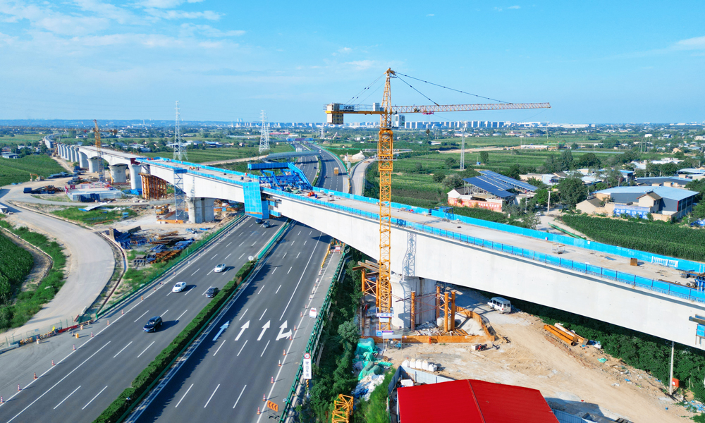 當(dāng)前，中國(guó)鐵建錨定高質(zhì)量發(fā)展目標(biāo)，堅(jiān)持不懈打造品質(zhì)工程，全力推動(dòng)各項(xiàng)重點(diǎn)工程建設(shè)。圖為由中鐵十一局承建的西延高鐵重難點(diǎn)工程清河特大橋跨京昆高速連續(xù)梁。西延高鐵建成后，對(duì)深入推進(jìn)西部大開(kāi)發(fā)戰(zhàn)略、助力革命老區(qū)鄉(xiāng)村振興、加快構(gòu)建包海高速鐵路通道具有重要意義。圖為大橋合龍施工現(xiàn)場(chǎng)。