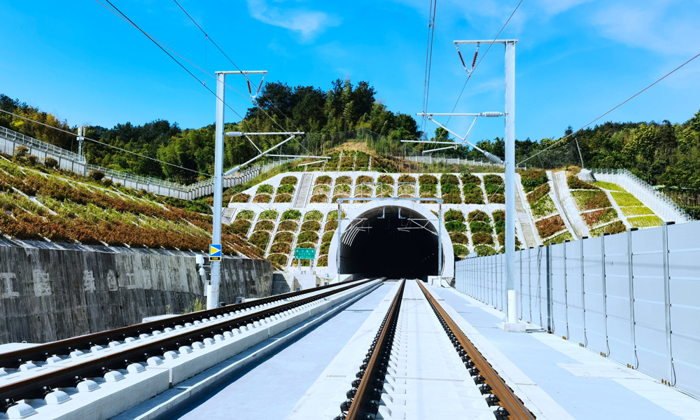 針對超高橋隧比難題，建設團隊開展丘陵地區短隧道群進洞技術措施研究及應用等復雜地質圍巖穩定性專項技術研究，發明了隧道襯砌拱頂帶模注漿效果監測裝置及監測方法、隧道預埋槽道焊接定位機構等多項隧道施工專利，為國內復雜地質條件下市內高鐵隧道建設提供有利參考。圖為宣績高鐵金沙隧道出口。