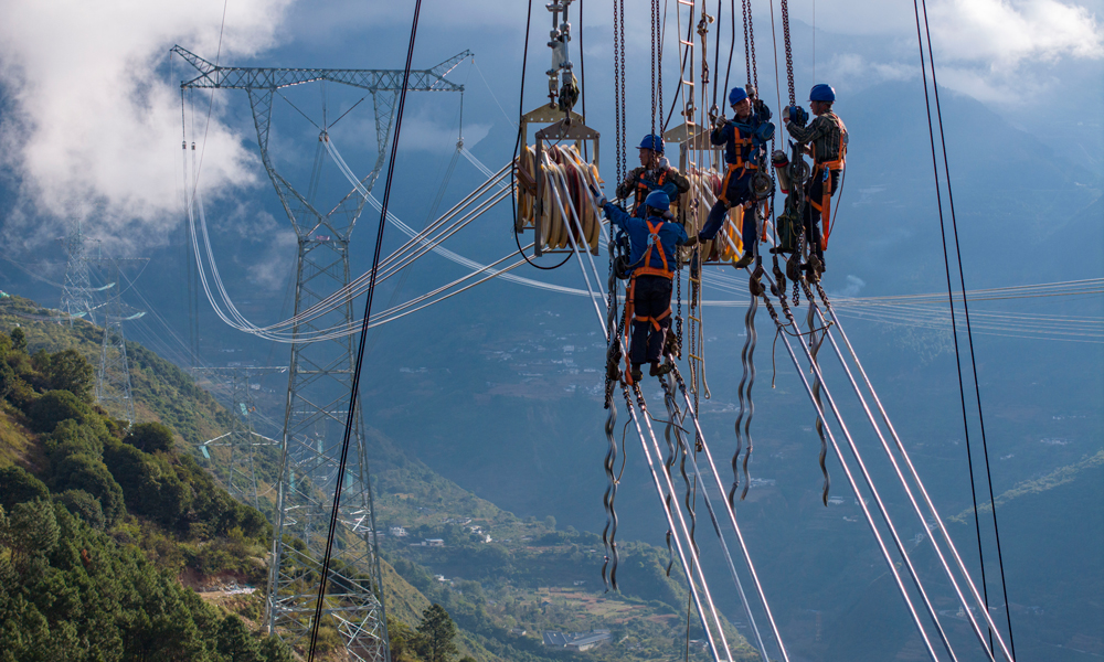 施工人員在川渝1000千伏特高壓交流工程8標段處進行收緊導線作業。
