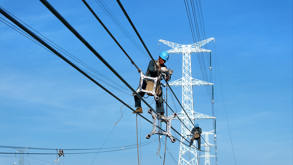 在500千伏廣東云浮云城輸變電工程現場，南方電網旗下廣東電網能源發展公司作業人員在新架線路上安裝間隔棒部件。