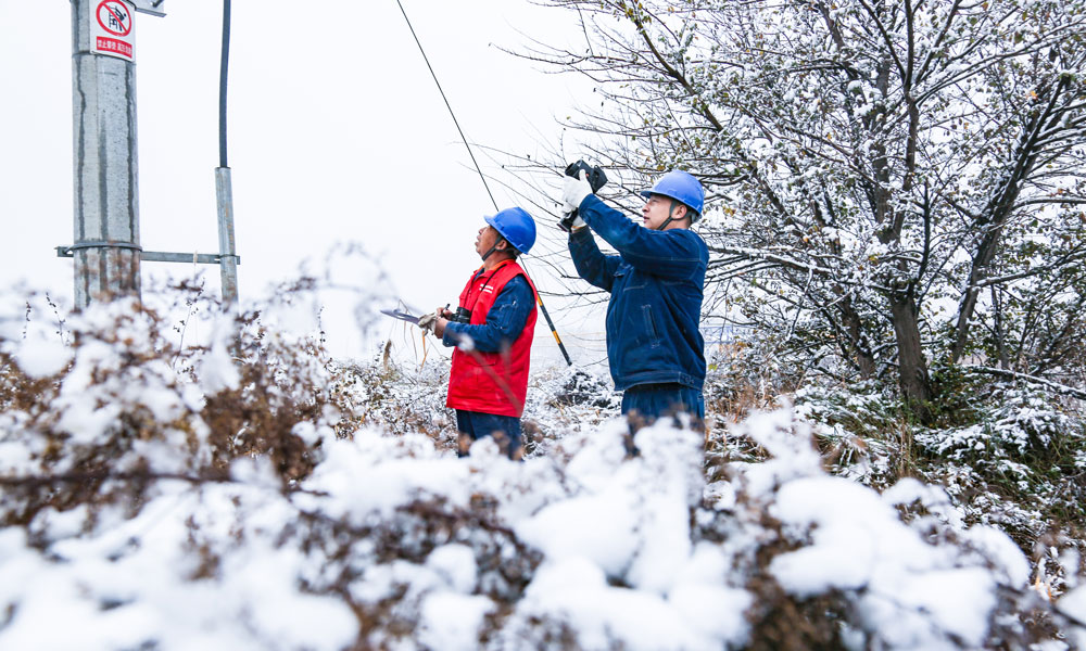 國家電網(wǎng)甘肅慶陽供電公司工作人員雪中特巡10千伏北大街線，確保配網(wǎng)線路設(shè)備安全穩(wěn)定運(yùn)行。