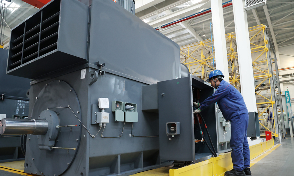 哈電集團佳電股份高壓電機數字化裝配車間現場，操作者在加工精細化工及原料工程項目，產品順利交付將助力我國石化產業向高端產業延伸，加快推動石化產業轉型升級。