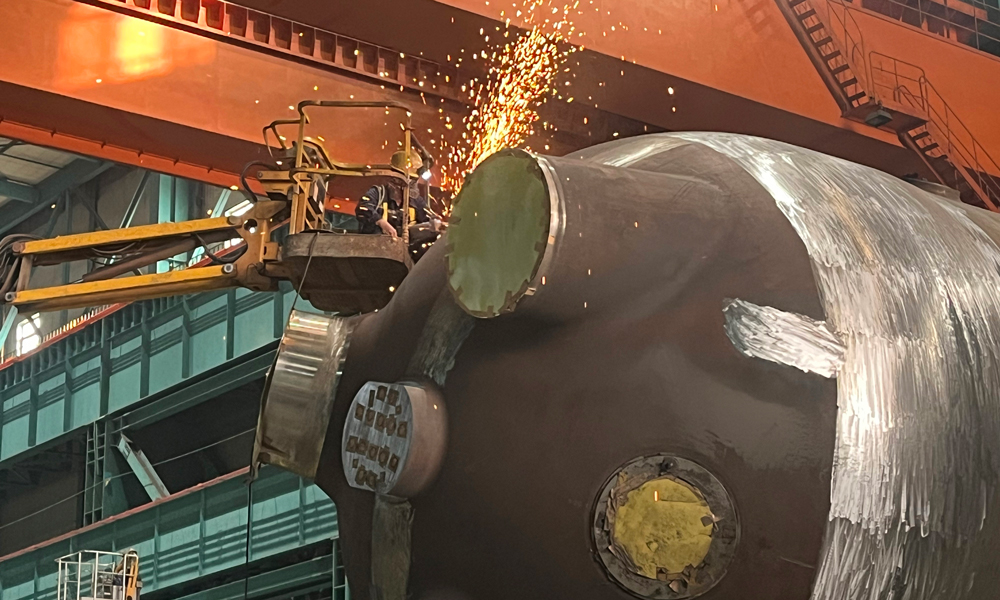 哈電集團重裝公司廉江項目生產現場，磨銼工在進行吊耳隔離層打磨的工作。