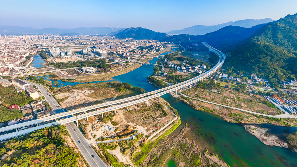 作為浙江省在建橋隧比最高的山區高速公路，瑞蒼高速北起瑞安市高樓鎮，南抵蒼南縣錢庫鎮，全長52.6公里，橋隧占比達87%。全線設置10座樞紐互通，包含36座橋梁、7座隧道，構建起連接龍麗溫、甬臺溫及甬臺溫復線三條高速的東西向快速通道，形成浙南山區與福建沿海的黃金走廊。圖為瑞蒼高速公路龍涵橋跨鰲江支流。