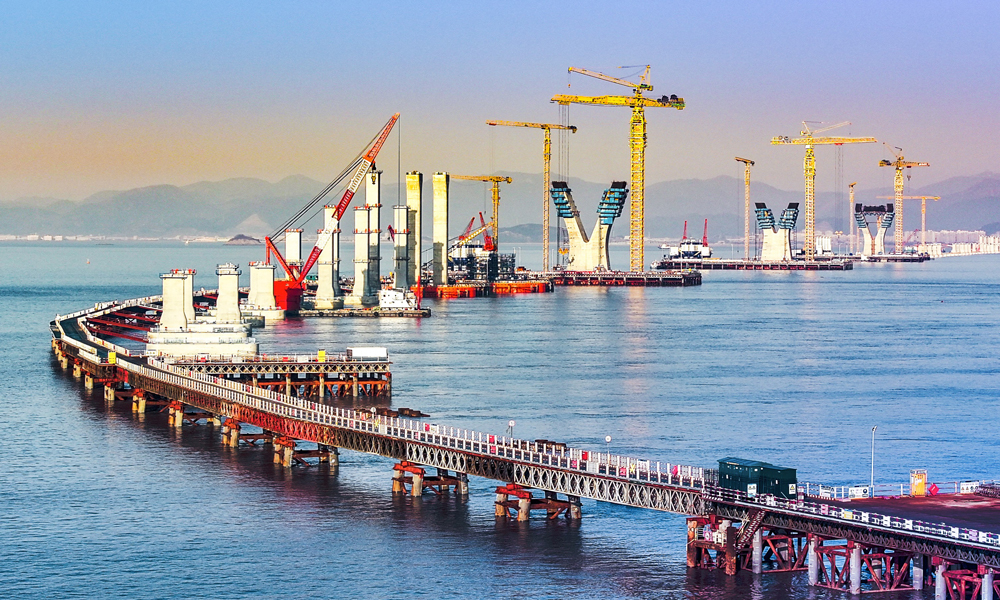 由中國(guó)鐵建大橋局參與建設(shè)的世界最大跨度三塔鋼箱梁斜拉橋青龍門大橋即將完成三座主塔下橫梁的提升作業(yè)。作為六橫大橋二期工程的關(guān)鍵控制性工程，青龍門大橋建成后將打通寧波和舟山南翼核心島嶼的陸海通道，進(jìn)一步促進(jìn)寧波舟山港港區(qū)及臨港產(chǎn)業(yè)基地發(fā)展，對(duì)促進(jìn)國(guó)家海洋經(jīng)濟(jì)發(fā)展戰(zhàn)略實(shí)施和國(guó)家級(jí)新區(qū)建設(shè)具有重要意義。圖為青龍門大橋東引橋。