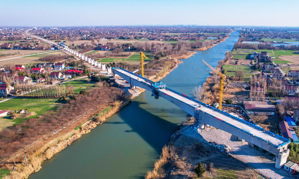 目前，中鐵十四局參建的滬渝蓉高鐵項(xiàng)目正全力推進(jìn)連續(xù)梁施工作業(yè)。該集團(tuán)承建的標(biāo)段全長(zhǎng)32.55公里，標(biāo)段內(nèi)主體施工已完成近80%，預(yù)計(jì)2027年可建成通車。作為我國(guó)“八縱八橫”高速鐵路客運(yùn)通道中“沿江通道”的主線部分，項(xiàng)目建成后，將對(duì)深入實(shí)施長(zhǎng)江經(jīng)濟(jì)帶發(fā)展和長(zhǎng)三角一體化發(fā)展戰(zhàn)略、促進(jìn)區(qū)域經(jīng)濟(jì)社會(huì)高質(zhì)量發(fā)展具有重要意義。圖為滬渝蓉高鐵通泰揚(yáng)特大橋跨如海運(yùn)河連續(xù)梁施工現(xiàn)場(chǎng)。
