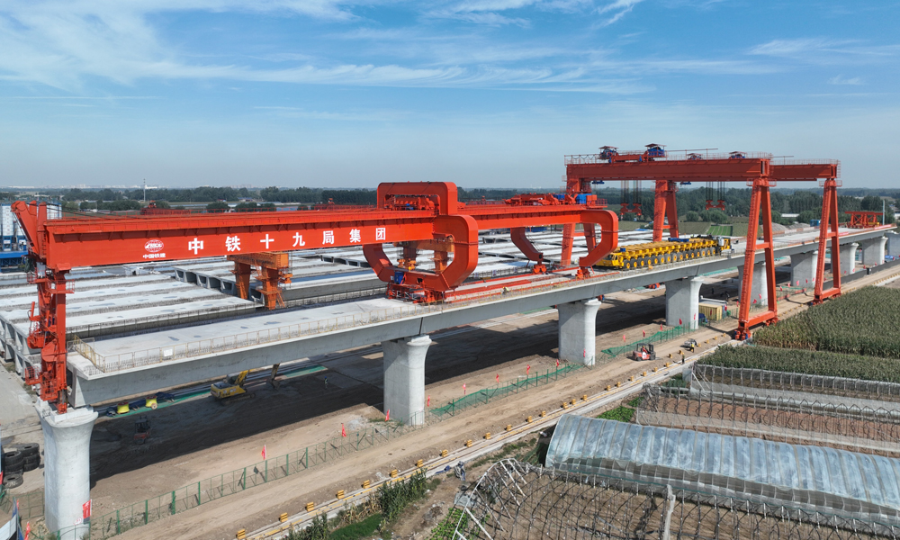 近日，中鐵十九局雄商高鐵項(xiàng)目部完成全部865孔箱梁架設(shè)任務(wù)，正式進(jìn)入無砟軌道施工階段，為全線按期通車奠定堅(jiān)實(shí)基礎(chǔ)。雄商高鐵預(yù)計(jì)于2026年具備通車條件，通車后將進(jìn)一步完善京津冀軌道交通網(wǎng)，對(duì)于貫徹實(shí)施京津冀協(xié)同發(fā)展國(guó)家戰(zhàn)略，促進(jìn)沿線經(jīng)濟(jì)社會(huì)發(fā)展等具有重要意義。圖為雄商高鐵架梁作業(yè)現(xiàn)場(chǎng)。