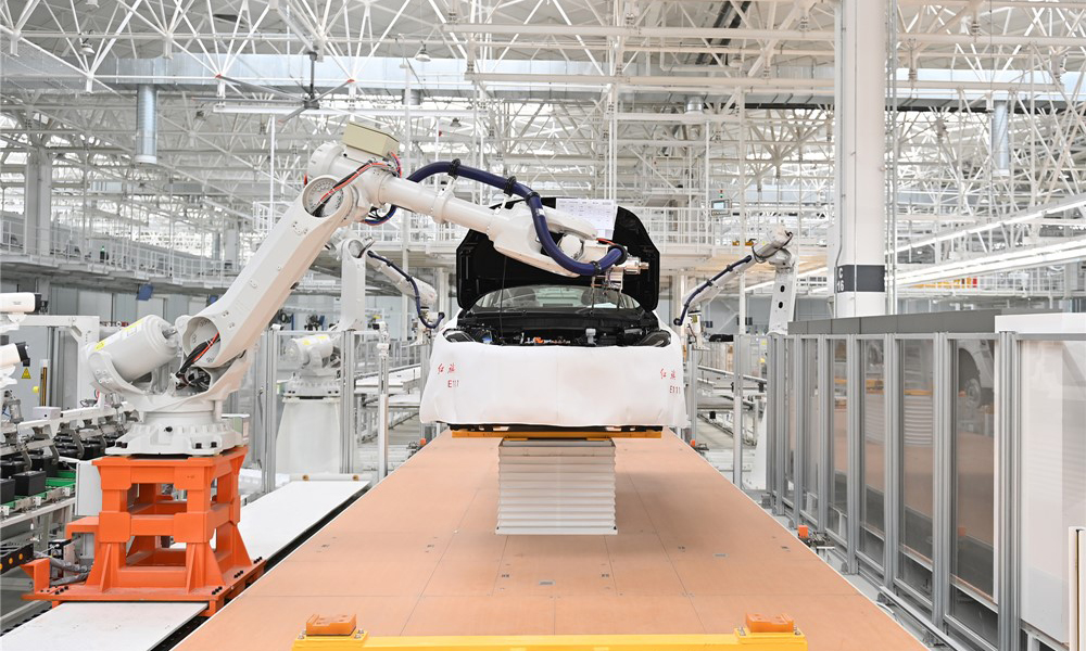 在生產車間，工作人員操作智能設備自動裝配蓄電池及備胎，像玩“華容道”一樣精準卡位，備胎和電瓶嚴絲合縫。