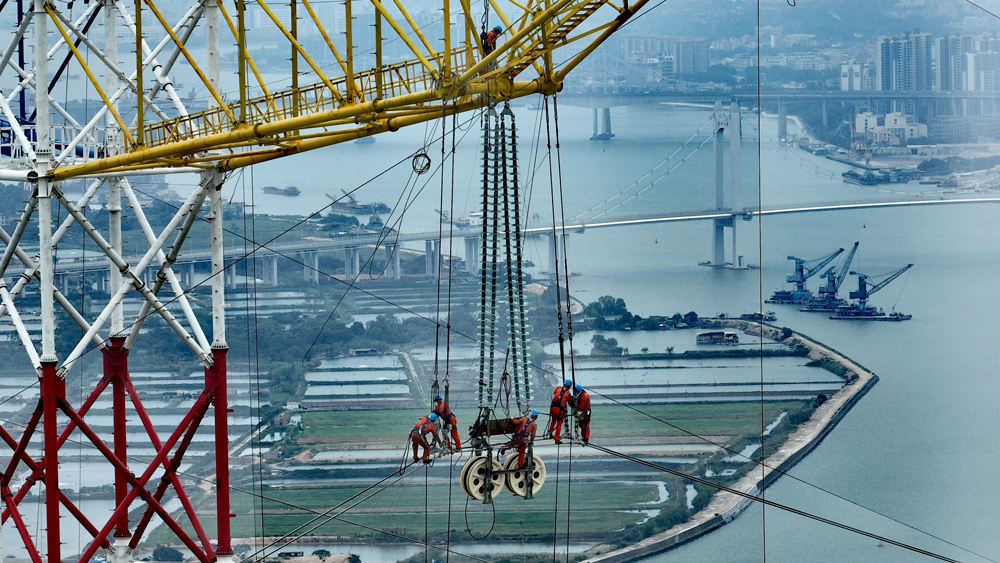 深山立塔、穿海聯網、智造重器……近日，南方電網多個重點工程項目建設現場熱火朝天。建設者們堅守一線，為推進新型電力系統建設，實現節能降碳，加強民生服務貢獻力量。圖為施工人員在500千伏沙獅甲乙線獅子洋大跨越改造工程現場開展導線展放作業。據悉，獅子洋大跨越改造工程預計在今年5月全線竣工投運，將有效提升廣東南部通道的輸電能力，為即將到來的第十五屆全國運動會及粵港澳大灣區高質量發展提供穩定電力。