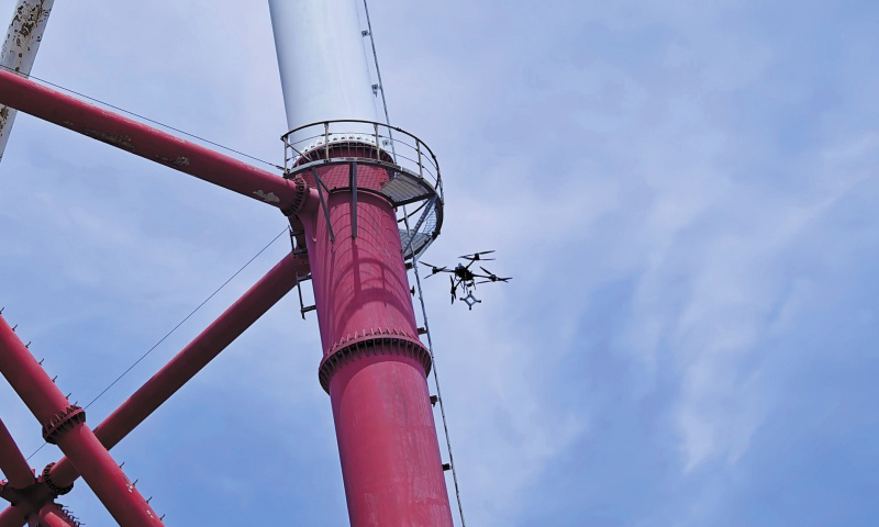 國家電網(wǎng)工作人員使用運(yùn)載無人機(jī)運(yùn)輸間隔棒。