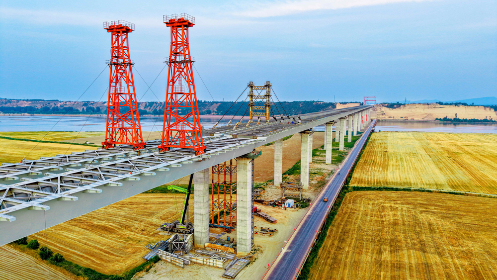 大橋兩岸分別為焦作市溫縣和鄭州市滎陽市，跨越黃河主河道而設(shè)的主橋全長(zhǎng)3656米，共分7聯(lián)，分幅設(shè)計(jì)，橋面寬2×16.55米，上部結(jié)構(gòu)為槽型開口鋼混組合梁，下部結(jié)構(gòu)為花瓶墩、承臺(tái)樁基礎(chǔ)。主梁采用頂推法施工，最大懸臂長(zhǎng)100米，是國(guó)內(nèi)在建橋梁槽型開口鋼混組合梁中頂推懸臂跨度最大、規(guī)模體量第一的橋梁。中鐵工業(yè)中鐵九橋主要承擔(dān)該橋第5至7聯(lián)共計(jì)約1.89萬噸鋼結(jié)構(gòu)制安任務(wù)。