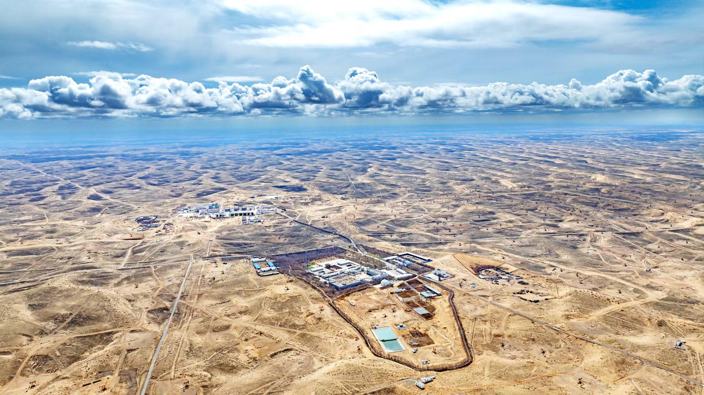 70年來，承載著“新中國第一個大油田”的使命與責任，新疆油田從“一號井”噴涌出工業油流開始，一路砥礪前行，發展成為如今年產油氣當量突破千萬噸的大型油氣田。“安下心、扎下根、不出油、不死心”的精神，早已深深根植于每一位新疆石油人的心中。站在新的歷史起點上，新疆油田全體工作人員正全力推動資源開發實現提速、擴量、增效，向著2000萬噸的歷史性跨越奮勇邁進。圖為位于古爾班通古特沙漠腹地的新疆油田采氣一廠克拉美麗氣田。 　