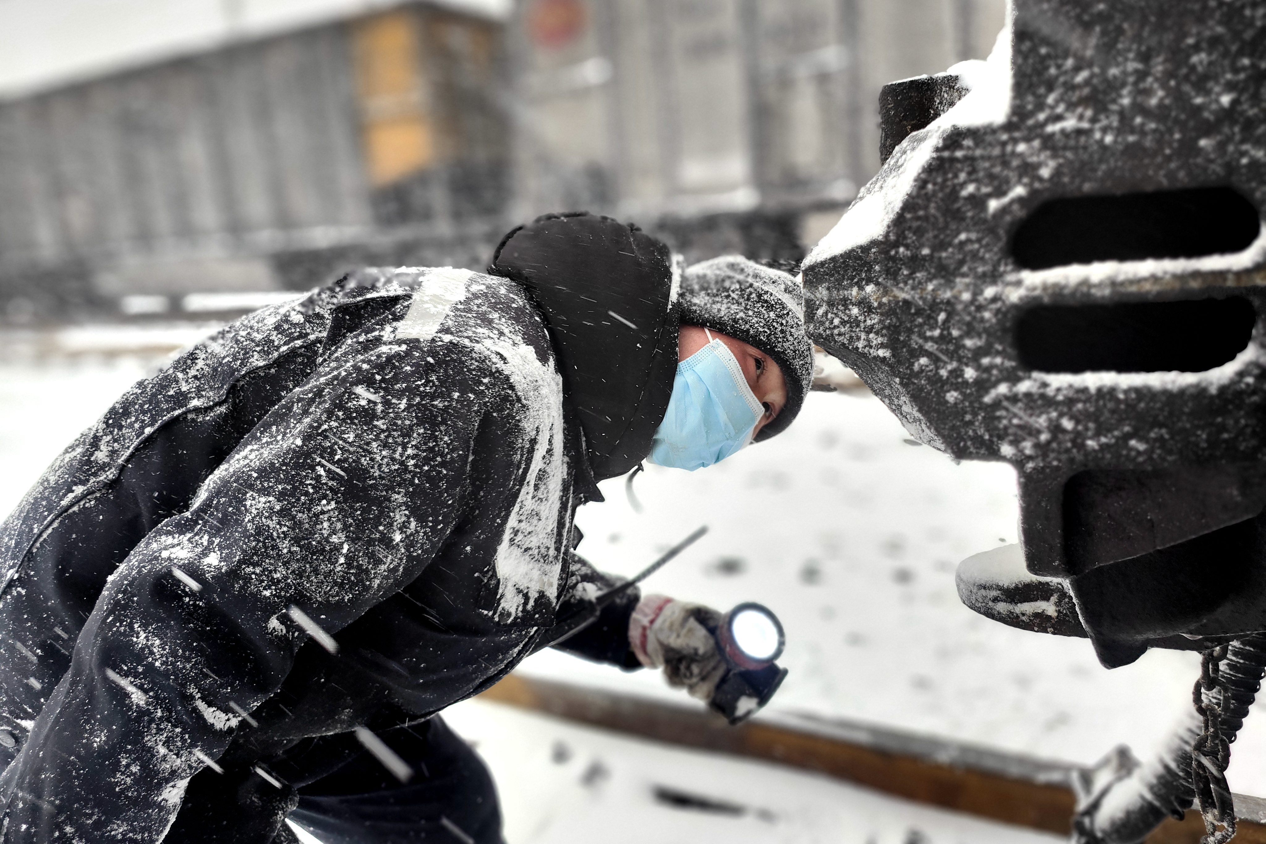 圖為1月20日鐵路裝備肅寧分公司肅寧北列檢作業場檢車員冒雪對車鉤部位進行檢查-王建_副本.jpg 圖為1月20日鐵路裝備肅寧分公司肅寧北列檢作業場檢車員冒雪對車鉤部位進行檢查-王建_副本.jpg