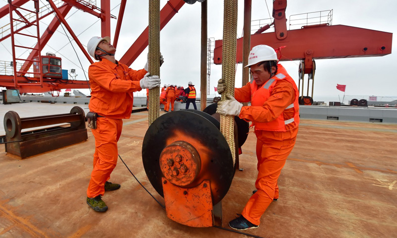 圖為12月28日，工人在平潭海峽公鐵兩用大橋大小練島水道橋上檢查鋼桁梁掛設(shè)情況。（新華社記者 林善傳 攝）