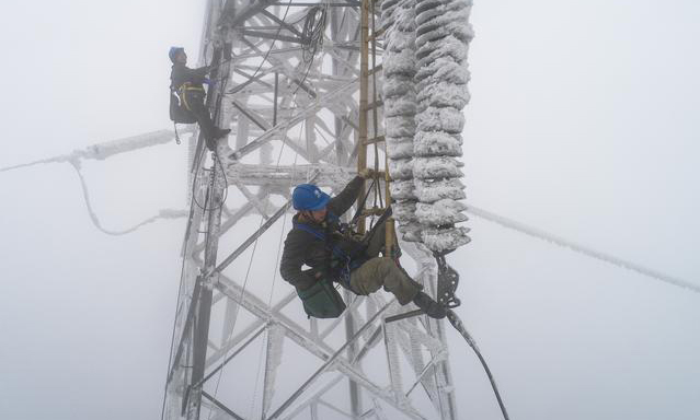 2月12日，受雨雪冰凍天氣影響，國網湖北省電力公司一供電線路出現故障，導致京廣高鐵橫店東至孝感北區段供電能力不足，造成途經該區段旅客列車不同程度晚點。故障發生后，國網武漢供電公司組織人員全力進行搶修。圖為搶修現場。（新華社記者 肖藝九 攝）