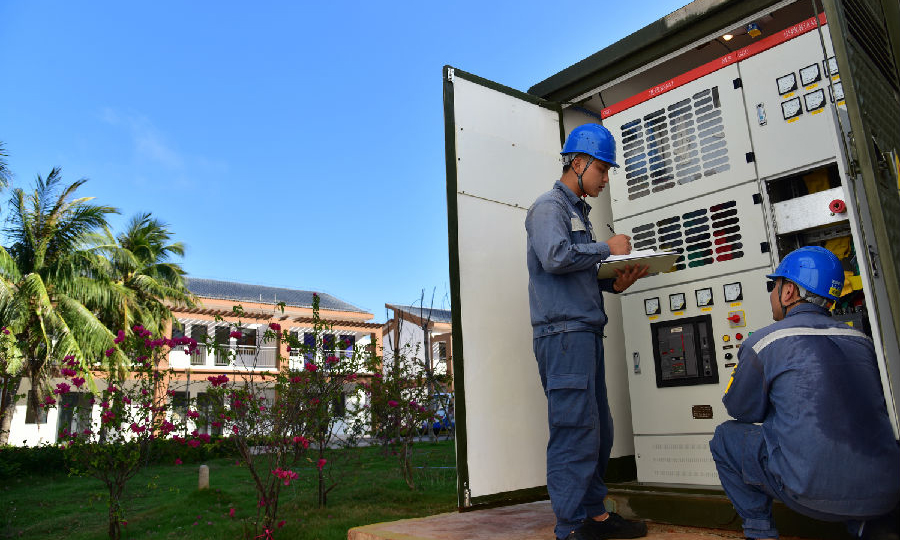 圖為近日，在海南省三沙市永興島，南方電網海南三沙供電局員工檢查箱式變電站，確保兩會期間安全穩定供電。（劉昌 攝）