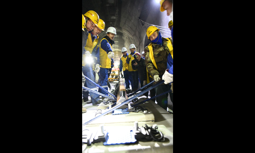 此次作業，為后續拉林鐵路無砟軌道長軌鋪設積累了經驗。圖為工作人員在香嘎山隧道鋪設長鋼軌。