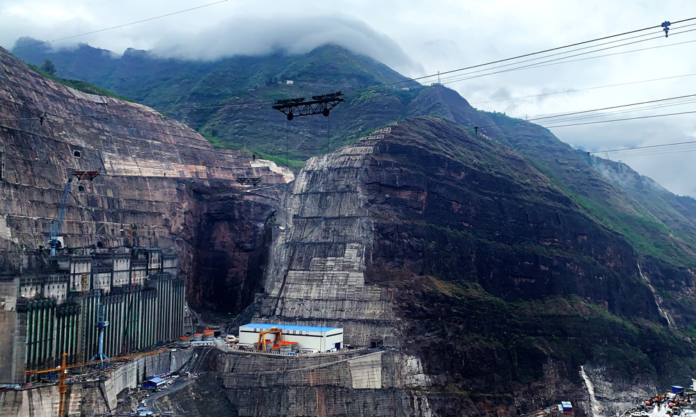 目前，全球在建裝機規(guī)模最大水電站——白鶴灘水電站正加緊建設。圖為6月26日拍攝的白鶴灘水電站建設工地。（國務院國資委網(wǎng)站 馬語謙 攝）
