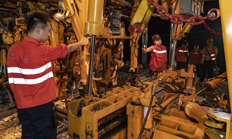 圖為7月19日凌晨，中鐵十一局三公司技術人員在指揮大型搗固車，對新鋪設的道岔進行大機養(yǎng)護。（新華社記者 杜華舉 攝）