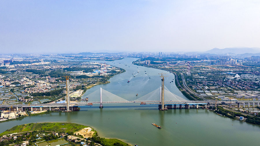 南沙港鐵路跨西江斜拉橋全長 1117.5 米，屬鋼箱混合雙主梁結構，塔高超過 200 米，主跨跨徑為 600 米，是世界雙線貨運鐵路建設史上同類型結構跨度最大的斜拉橋。圖為建設中的南沙港鐵路跨西江斜拉橋。（金偉 攝）