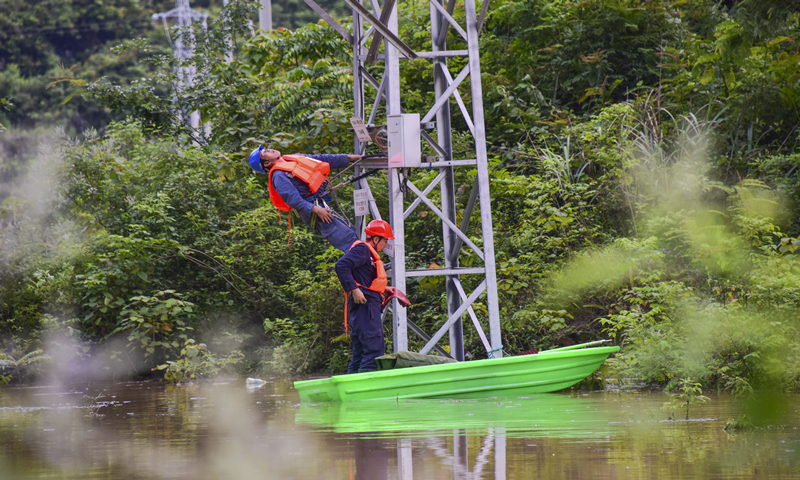 圖為6月6日，由于水勢持續上漲，南方電網廣西河池羅城供電局立即對受災線路進行隔離。（余菲 攝） 