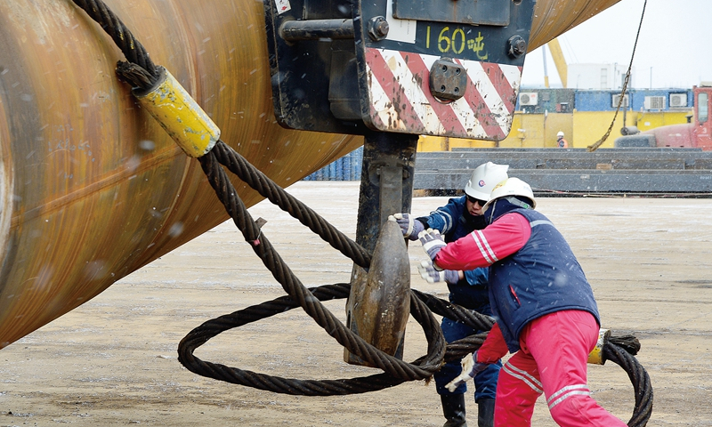 陸地遺留的工作海上干，海上的工作加班干。在海上施工期間，為爭取時效，項(xiàng)目組首先將腦筋動在生活支持、平臺送電、水源井啟用、海管通球等幾項(xiàng)重點(diǎn)任務(wù)的組織上，并在重點(diǎn)設(shè)備的調(diào)試上“盯梢”。臨近施工關(guān)鍵期，遠(yuǎn)在異地的況昕、陳華、李云龍等人紛紛請纓助陣海上聯(lián)合調(diào)試，給早已身心疲憊的現(xiàn)場工程師岑亮、王從洋、付曉飛、關(guān)海崢等人提神鼓勁。圖為施工人員掛扣鎖具，進(jìn)行導(dǎo)管架立片工作。
