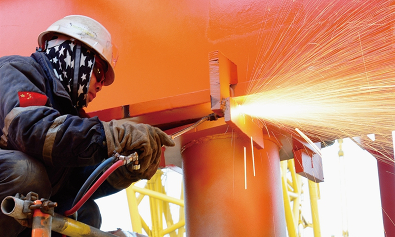 項(xiàng)目組通過發(fā)揮工程建設(shè)中心在區(qū)域項(xiàng)目統(tǒng)籌管理方面的優(yōu)勢，協(xié)調(diào)海上資源，按既定奮斗目標(biāo)倒排工期、按日消項(xiàng)，一點(diǎn)一點(diǎn)掙出了時間，搶出了工期，讓這對“雙胞胎”平臺以最快速度在海上安家。圖為施工人員正在切割組塊結(jié)構(gòu)物的連接部分。