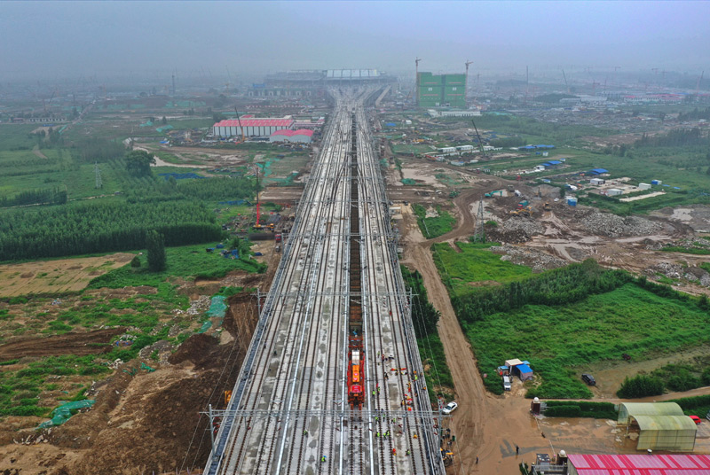 8月17日，京雄城際鐵路最后一組500米長(zhǎng)鋼軌在河北雄安新區(qū)鋪設(shè)完成，標(biāo)志著京雄城際鐵路全線(xiàn)軌道貫通。圖為8月17日，鋪軌機(jī)停靠在京雄城際鐵路上準(zhǔn)備鋪軌。（新華社記者 牟宇 攝）