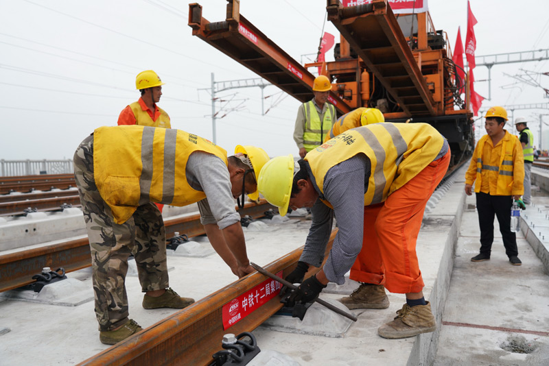 圖為8月17日，中鐵十二局工人在進(jìn)行鋪軌作業(yè)。（新華社記者 牟宇 攝）