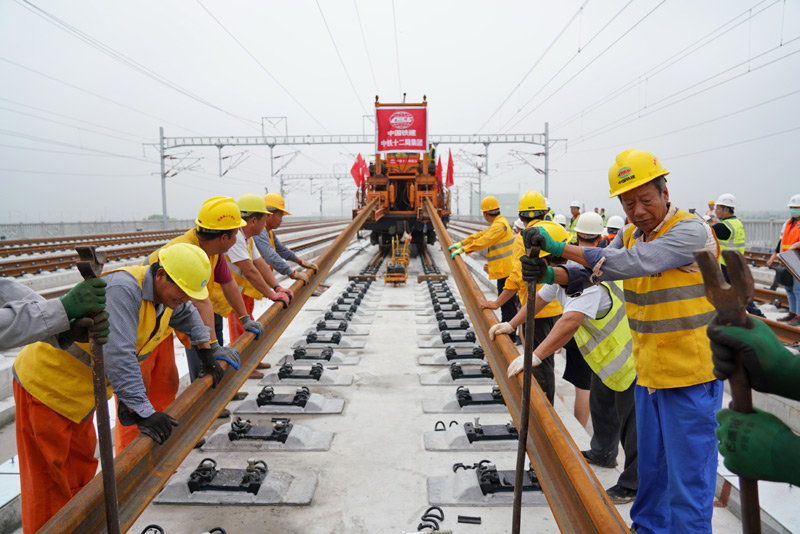 圖為8月17日，中鐵十二局工人在進(jìn)行鋪軌作業(yè)。（新華社記者 牟宇 攝）