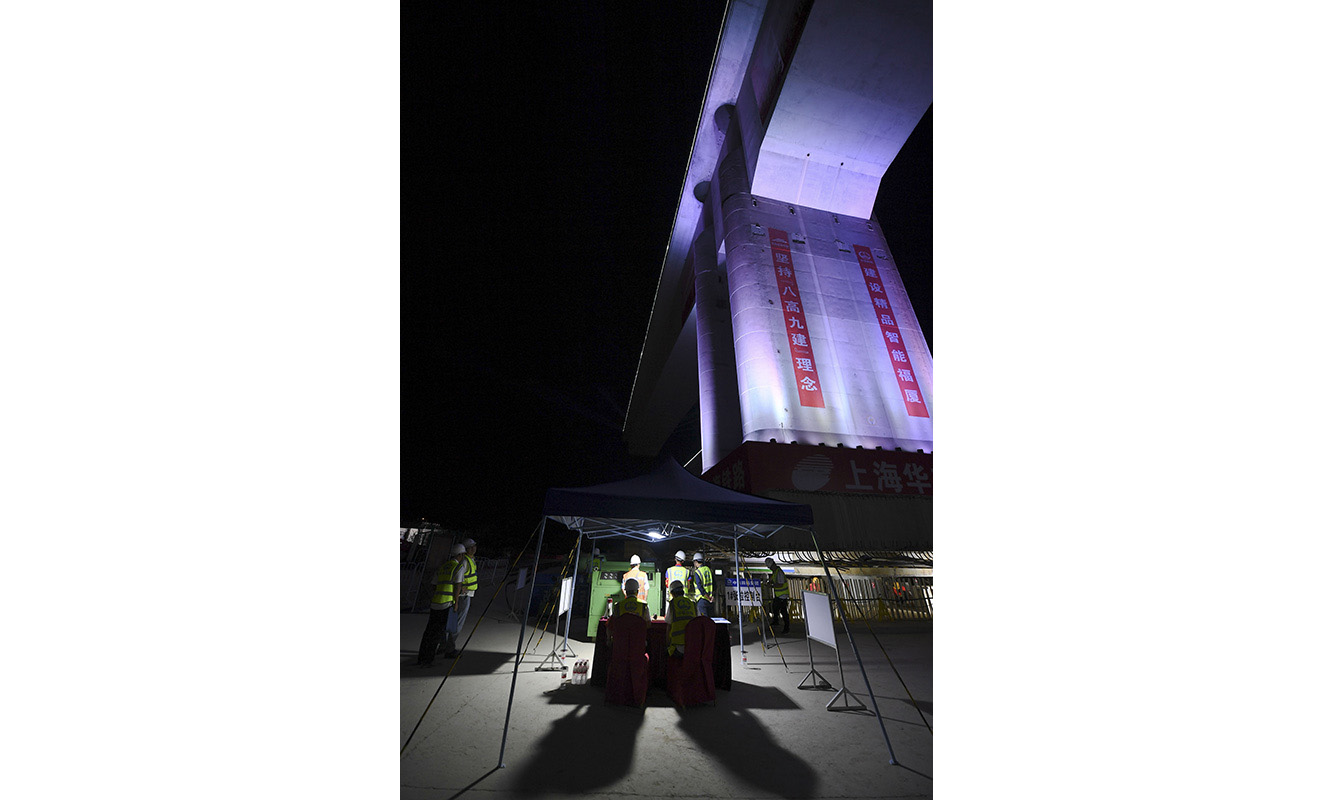 新建福廈鐵路設(shè)計(jì)時(shí)速350公里，預(yù)計(jì)2022年通車。圖為9月23日晚，技術(shù)人員在轉(zhuǎn)體梁下方指揮轉(zhuǎn)體作業(yè)。（新華社記者 宋為偉 攝）