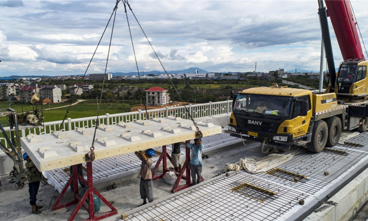 圖為8月30日，中鐵十一局職工在江西省豐城市境內(nèi)的昌贛高鐵孫渡特大橋上吊裝無砟軌道板。（新華社記者 杜華舉 攝）