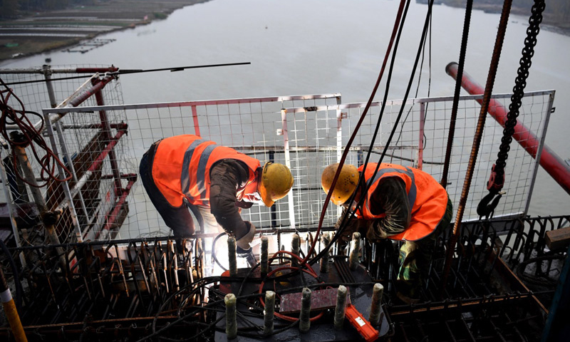 商合杭鐵路由河南商丘站引出，途經(jīng)安徽亳州、阜陽(yáng)、合肥等地區(qū)，在蕪湖跨越長(zhǎng)江，引入杭州站，線路全長(zhǎng)794.55公里，設(shè)計(jì)時(shí)速350公里。圖為11月17日，施工人員在商合杭鐵路跨淮河特大橋合龍現(xiàn)場(chǎng)作業(yè)。（新華社記者 劉軍喜 攝）