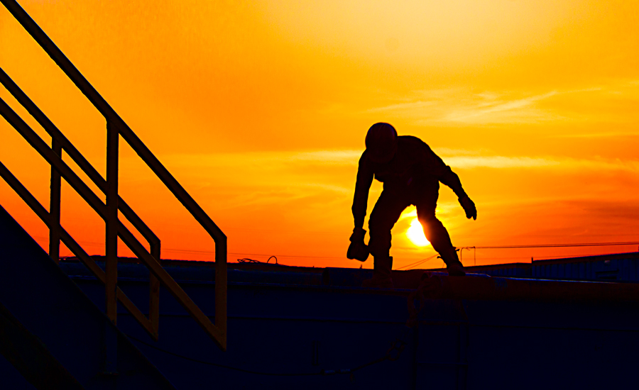 2017年5月28日，夕陽(yáng)西下，湖北省潛江市江漢油田五七一鉆井隊(duì)，一名鉆井工正在鉆桿上檢查鉆桿質(zhì)量，為下鉆做準(zhǔn)備。（作者：曾黎紅）